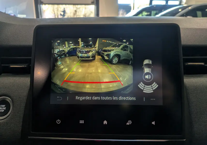 Écran central de la Renault Clio V Bleu Iron montrant la caméra de recul avec guidage de trajectoire en intérieur.