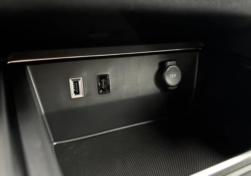 Vue rapprochée de la console centrale noire du Citroën C5 Aircross 2025 avec prises USB et prise 12V.