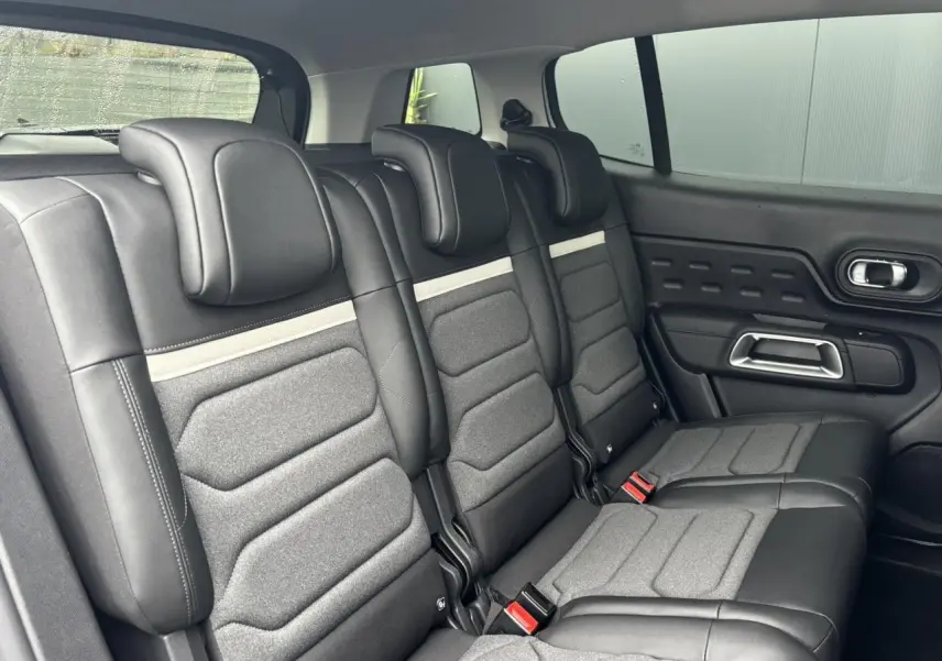 Vue latérale intérieure des trois sièges arrière indépendants en cuir et tissu gris du Citroën C5 Aircross 2025.