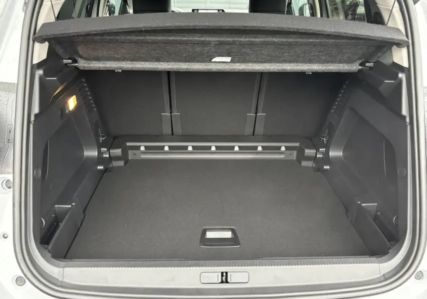 Coffre ouvert vu de l'arrière du Citroën C5 Aircross blanc Okénite, montrant un espace de chargement propre et modulable.