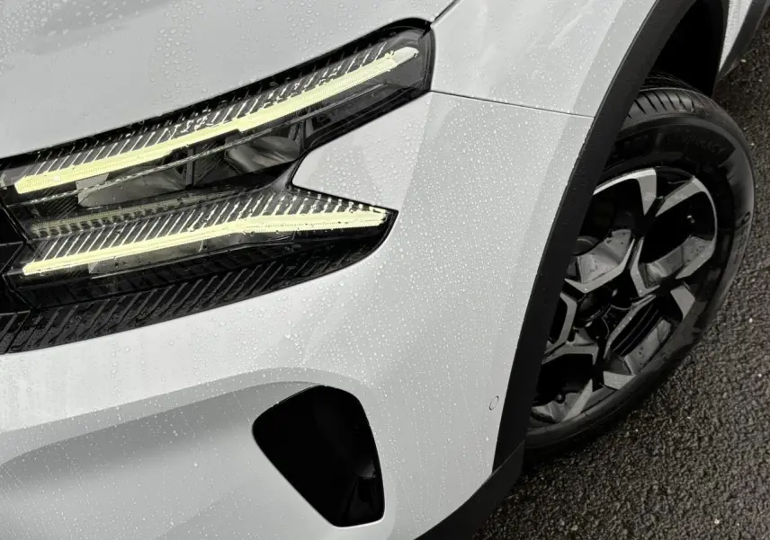 Gros plan sur l'avant droit blanc Okénite du Citroën C5 Aircross 2025 avec phares LED et jante alliage bi-ton.