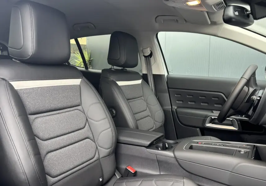 Vue intérieure côté droit des sièges avant en tissu et cuir noir avec surpiqûres claires du Citroën C5 Aircross 2025.