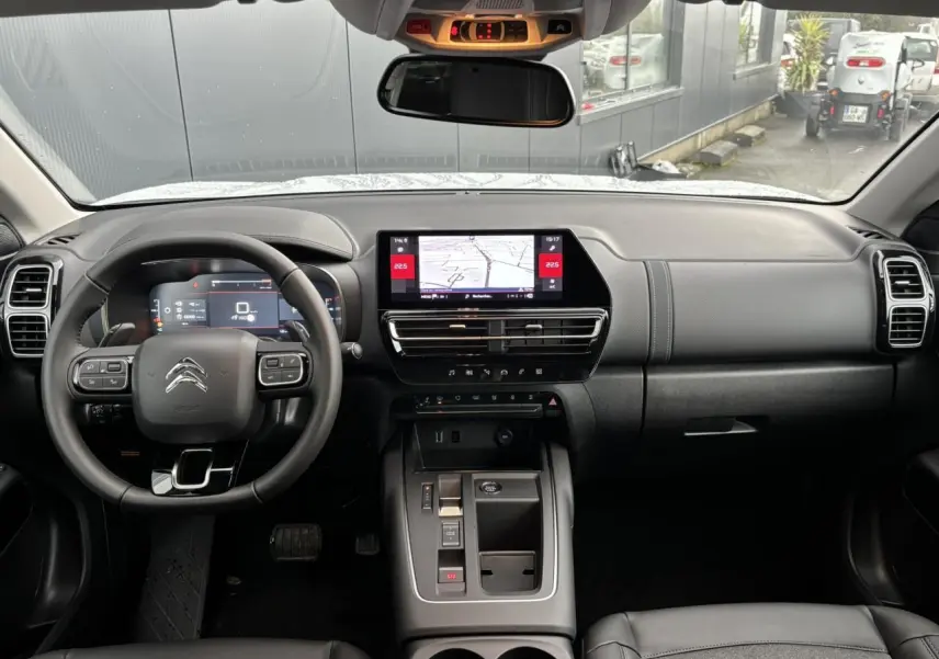 Vue intérieure avant du Citroën C5 Aircross 2025, tableau de bord noir avec écran tactile central et volant multifonction.
