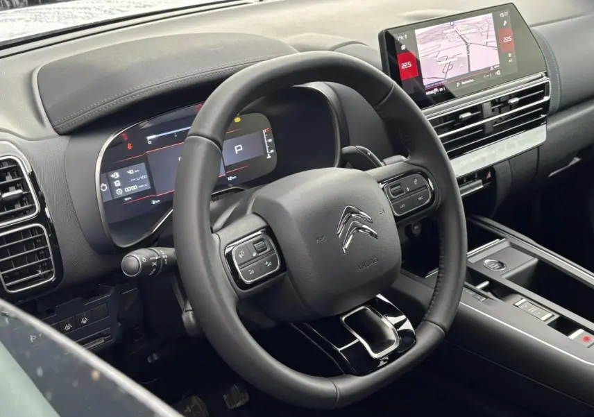 Vue rapprochée du volant et du tableau de bord numérique du Citroën C5 Aircross blanc, avec écran tactile et commandes intégrées.