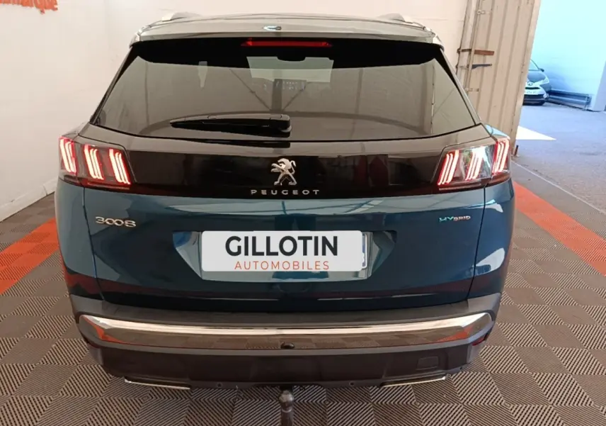 Vue arrière d’un Peugeot 3008 hybride bleu 2022 avec feux LED distinctifs et logo central sur hayon noir.