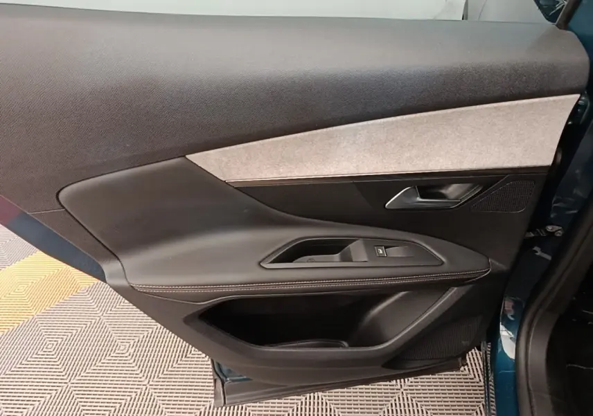 Vue intérieure de la porte arrière droite du Peugeot 3008 bleu, avec garniture noire et insert tissu clair.