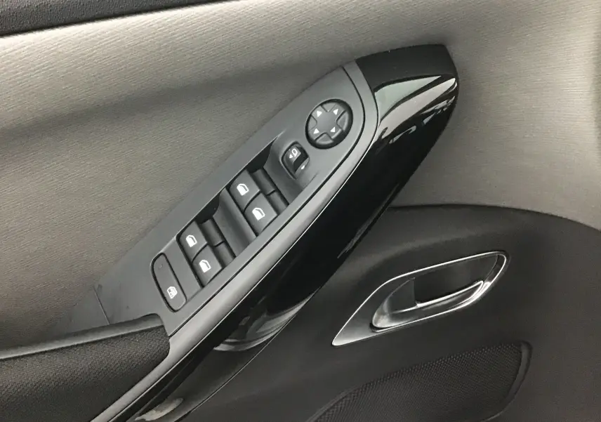 Gros plan sur la commande des vitres et le bouton de réglage des rétroviseurs côté conducteur du Citroën Grand C4 Spacetourer gris Artense.