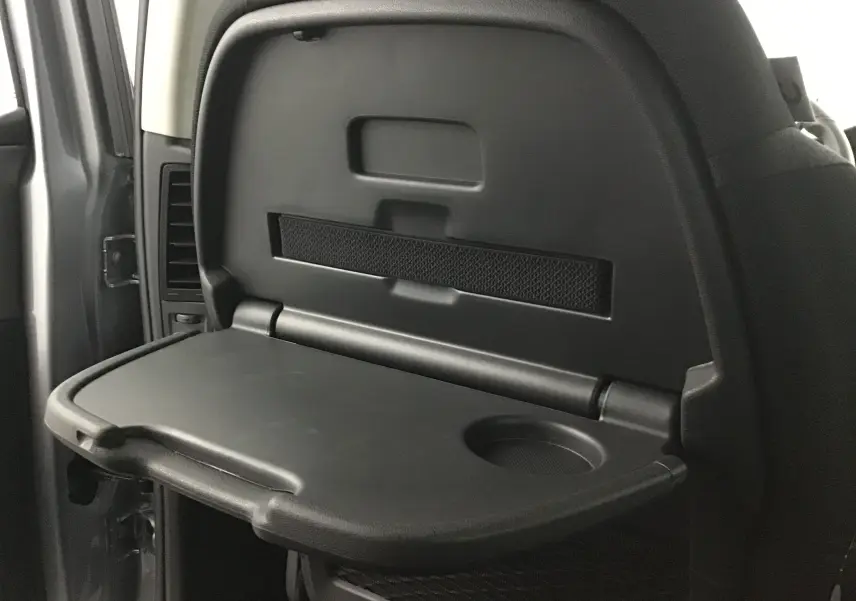 Tablette rabattable noire avec porte-gobelet intégrée sur le dossier d'un siège arrière d'un Citroën Grand C4 Spacetourer gris Artense.