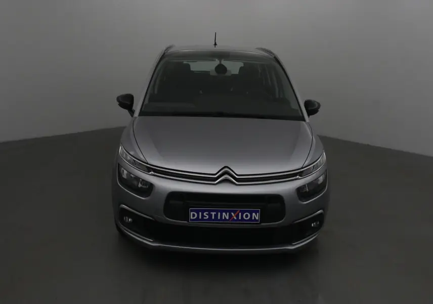 Vue frontale d'un Citroën Grand C4 Spacetourer gris Artense avec calandre distinctive et plaque Distinxion.