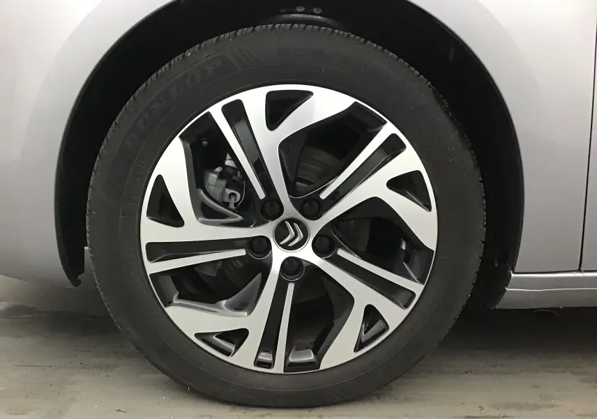 Gros plan sur la roue avant droite d'une Citroën Grand C4 Spacetourer gris Artense avec jante alliage bicolore.