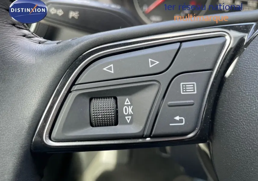 Gros plan sur les commandes au volant de l'Audi A3 Sportback 35 TFSI bleu cosmos, boutons de navigation et validation visibles.