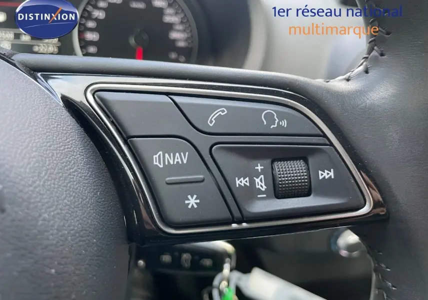 Gros plan sur les commandes du volant côté gauche de l'Audi A3 Sportback 35 TFSI bleu cosmos, avec boutons navigation et volume.