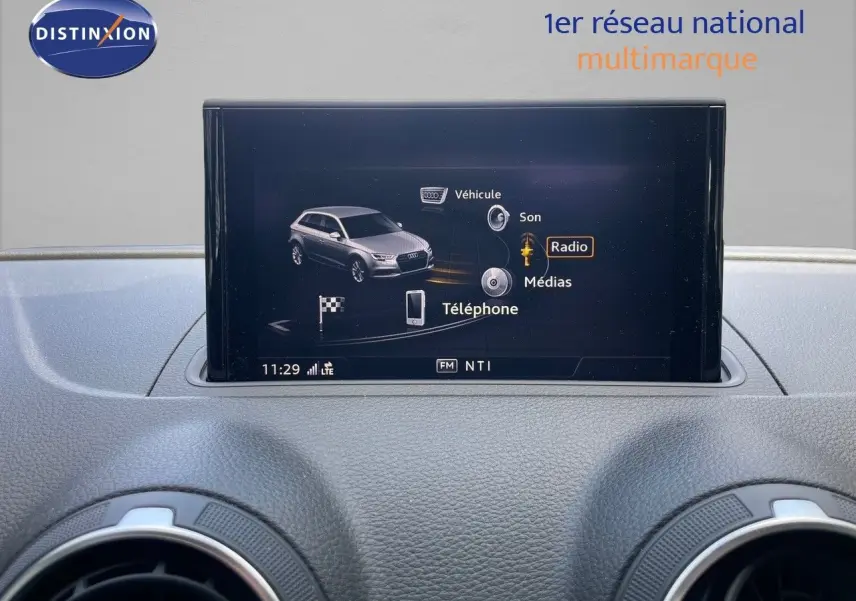 Écran central de l'Audi A3 Sportback 35 TFSI bleu cosmos, affichant le menu multimédia avec options radio et téléphone.
