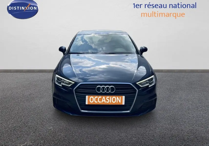 Vue frontale d'une Audi A3 Sportback bleu cosmos métal avec calandre hexagonale et phares LED allumés.