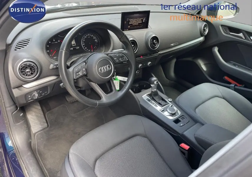 Intérieur de l'Audi A3 Sportback 2020 vu côté conducteur, tableau de bord noir avec écran central et volant multifonction.
