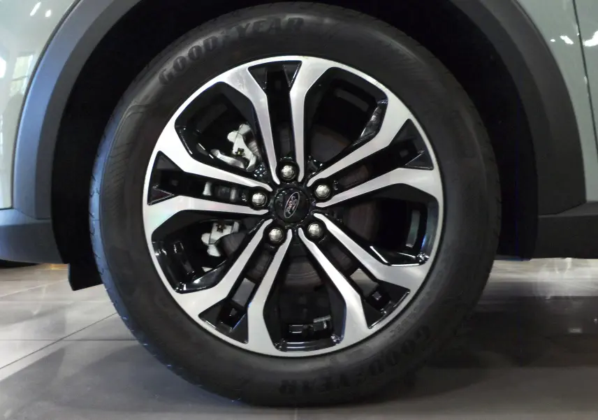 Gros plan sur la jante alliage bicolore du Ford Puma gris Cactus, mettant en valeur le logo Ford central.