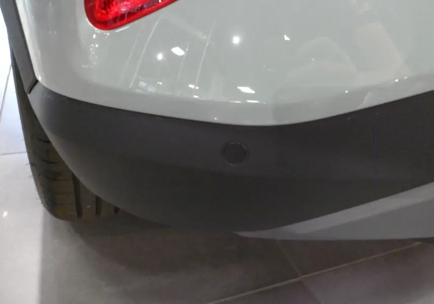 Gros plan sur le pare-chocs arrière gris cactus du Ford Puma 2025 avec capteur de recul intégré.