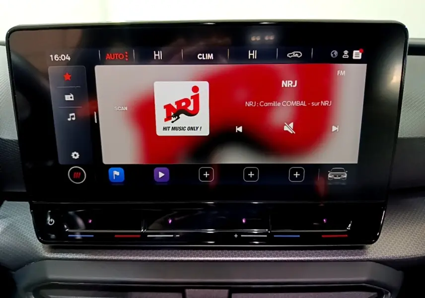 Écran tactile central allumé du tableau de bord de la SEAT Leon 2023, affichant la radio NRJ.