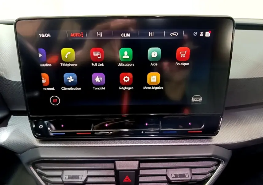 Écran tactile central du tableau de bord de la SEAT Leon 2023, affichant les menus multimédias et climatisation.