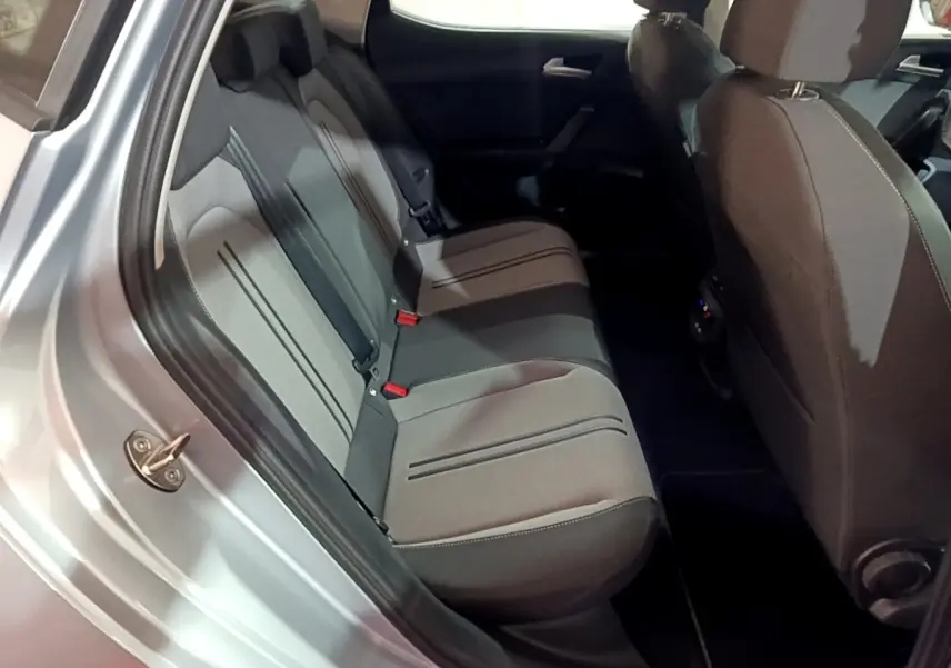 Vue intérieure côté arrière gauche montrant la banquette grise et les sièges avant du SEAT LEON gris clair 2023.