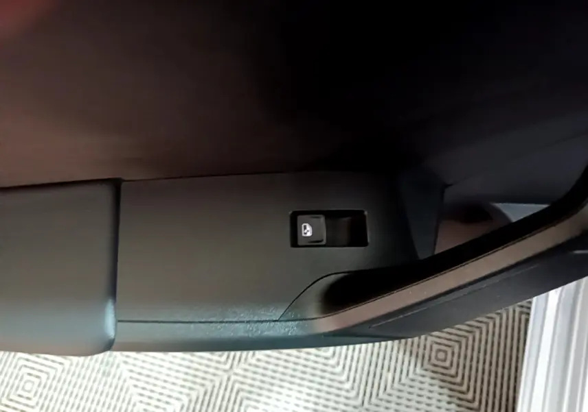 Bouton de verrouillage des portes sur la porte côté gauche d'une SEAT Leon gris clair, vue intérieure rapprochée.
