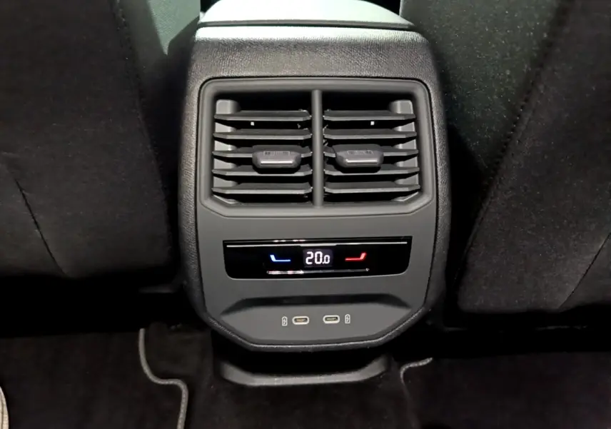 Vue rapprochée de la console arrière avec bouches d’aération, affichage digital de la climatisation et ports USB de la SEAT Leon 2023.