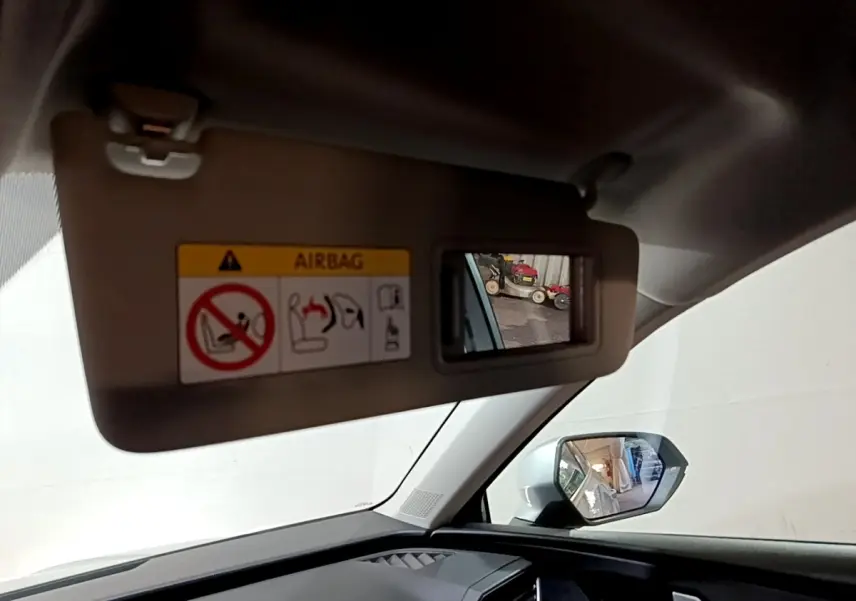 Détail du pare-soleil côté conducteur avec miroir intégré et rétroviseur extérieur gris clair d'une SEAT Leon 2023.