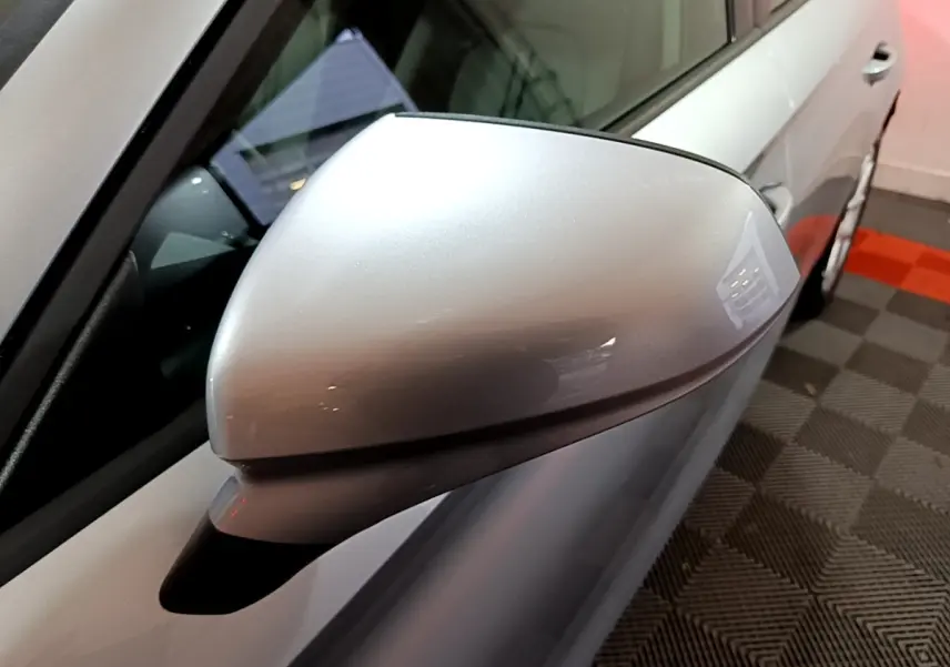 Rétroviseur côté gauche gris clair de la SEAT LEON 2023, vue rapprochée sur la portière et la vitre.