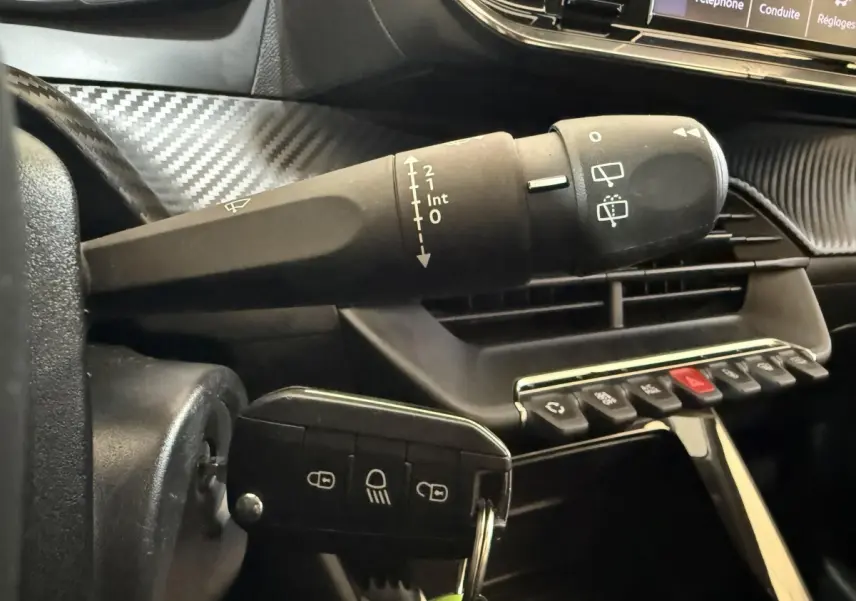 Gros plan sur la commande d’essuie-glace et la clé insérée dans le contacteur d’une Peugeot 208 PureTech 75 S&S Like 2020.