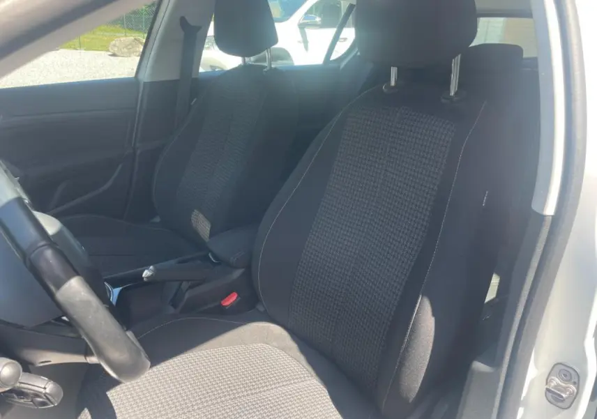Vue intérieure côté gauche montrant les sièges avant en tissu noir et gris d'une Peugeot 308 blanche 2020.