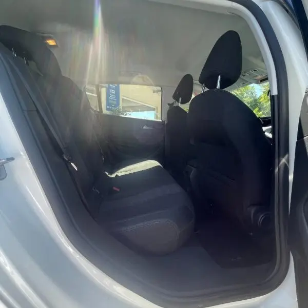 Vue intérieure côté gauche sur les sièges arrière noirs d'une Peugeot 308 blanche, version 5 portes, année 2020.