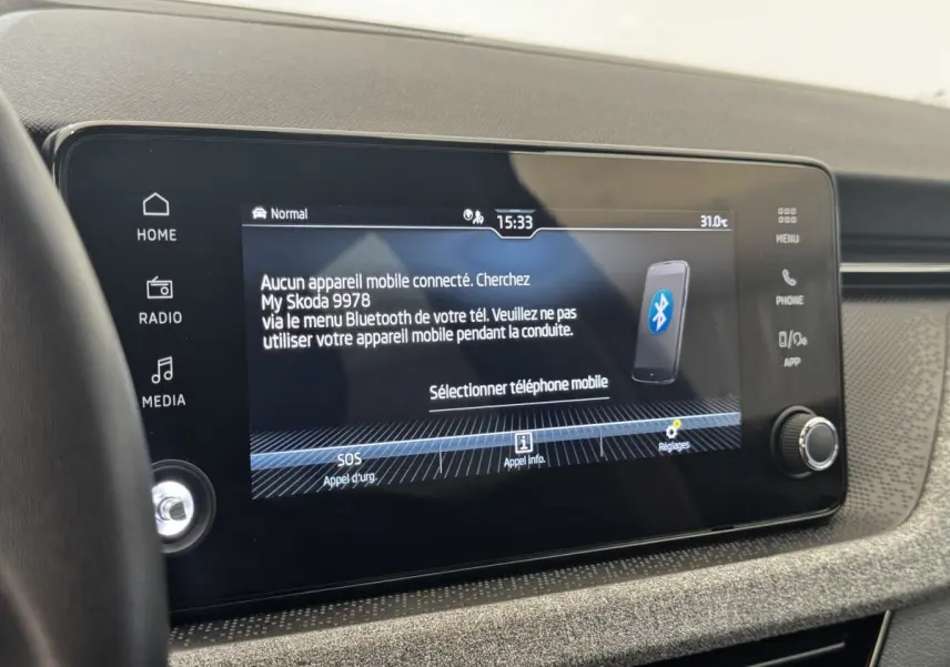 Écran tactile central allumé du tableau de bord d’une Skoda Scala gris clair, affichant la connexion Bluetooth.