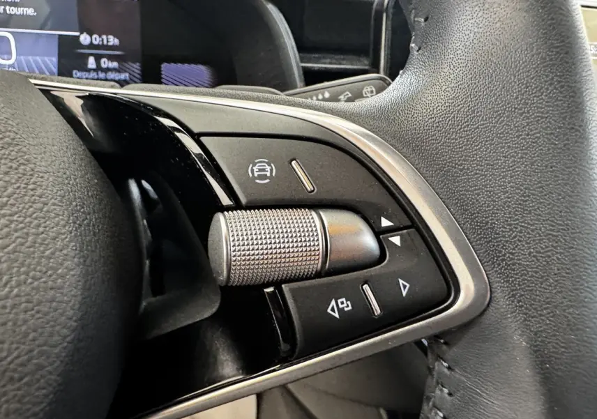 Gros plan sur les commandes multifonctions en alu et cuir du volant noir d'une Skoda Scala gris clair, version 2025.