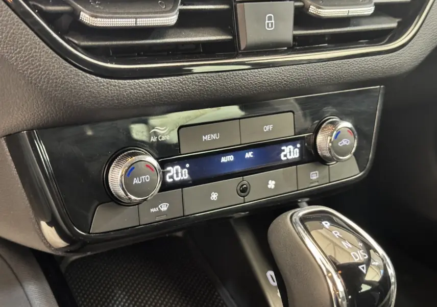 Gros plan sur la console centrale noire de la Skoda Scala 2025, montrant la climatisation automatique et le levier de vitesse.