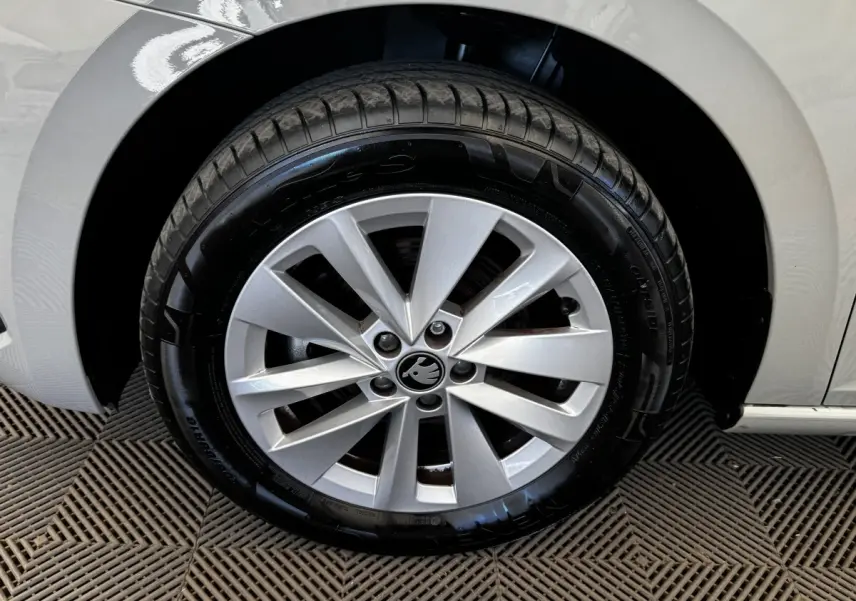 Gros plan sur la roue avant droite gris clair d’une Skoda Scala 1.0 TSI 116ch DSG7 avec jante alliage distinctive.