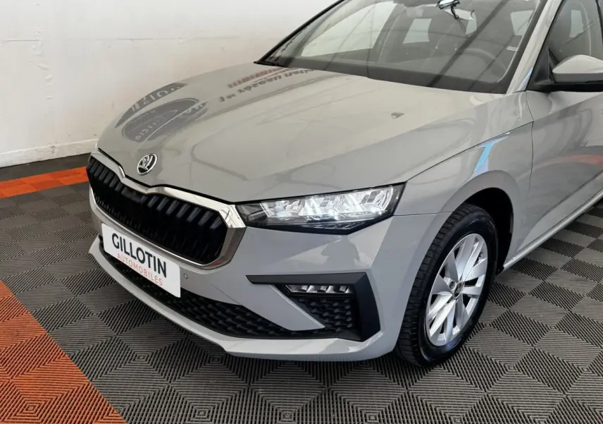 Vue 3/4 avant droite d'une Skoda Scala gris clair avec calandre noire et phares LED distinctifs.