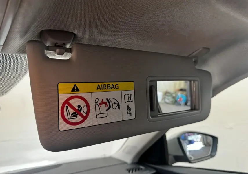 Détail du pare-soleil côté conducteur avec miroir et avertissement airbag dans une Skoda Scala gris clair.