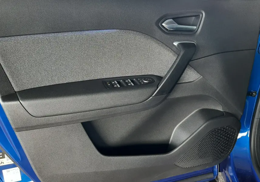 Vue intérieure de la porte avant gauche du Renault Captur bleu iron, avec commandes de vitres et tissu gris.
