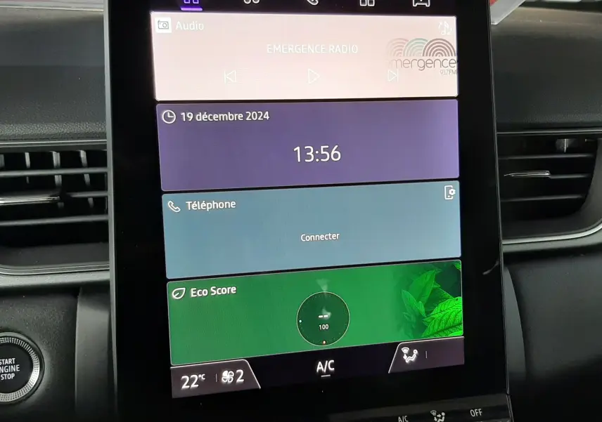 Écran tactile central du tableau de bord du Renault Captur E-Tech Hybrid 2024 affichant radio, téléphone et score écologique.