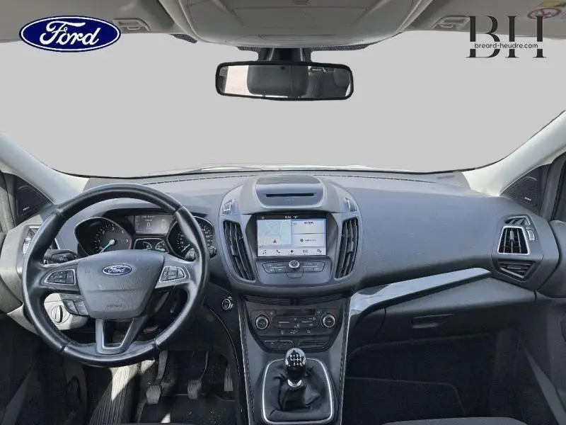 Vue intérieure frontale du tableau de bord du Ford Kuga 2017 avec volant cuir multifonction et écran tactile central.