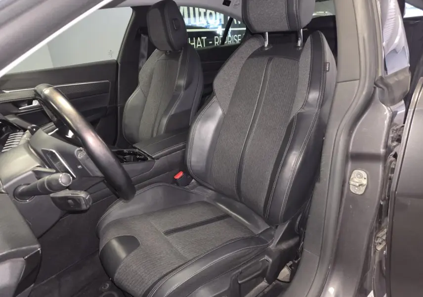 Intérieur côté conducteur d'une Peugeot 508 gris, siège tissu et cuir noir avec volant compact multi-fonctions visible.