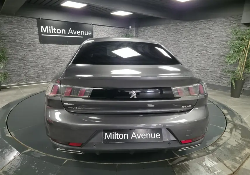 Vue arrière d'une Peugeot 508 gris métallisé avec feux arrière à trois griffes et double sortie d'échappement chromée.