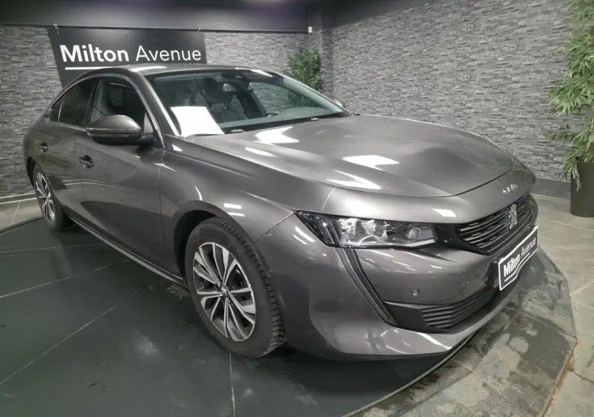 Peugeot 508 gris métallisé vue 3/4 avant droit avec calandre noire et jantes alliage 17 pouces.