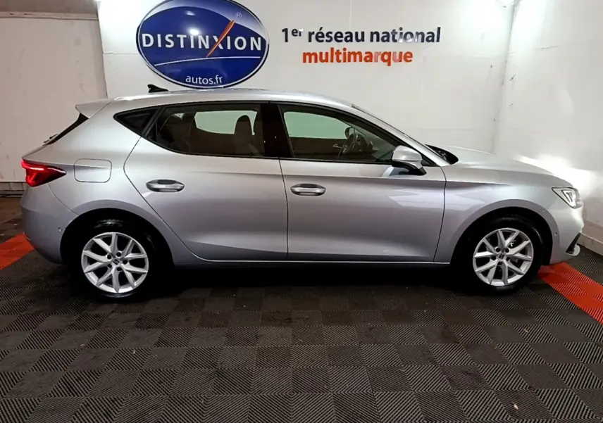 Profil côté gauche d'une SEAT Leon gris foncé 2023, en intérieur, avec jantes alliage et lignes épurées.