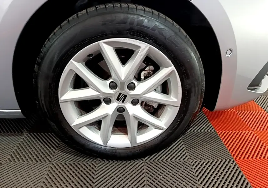 Gros plan sur la roue avant droite gris foncé d'une SEAT LEON 1.0 TSI 110 S&S Business avec jante alliage à 5 branches doubles.