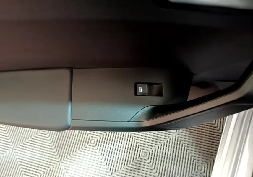 Bouton de déverrouillage de coffre sur la porte côté gauche d'une SEAT LEON gris foncé 2023 vue en gros plan intérieur
