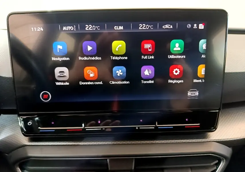 Écran tactile central du tableau de bord de la SEAT LEON gris foncé, affichant les menus multimédias et climatisation.