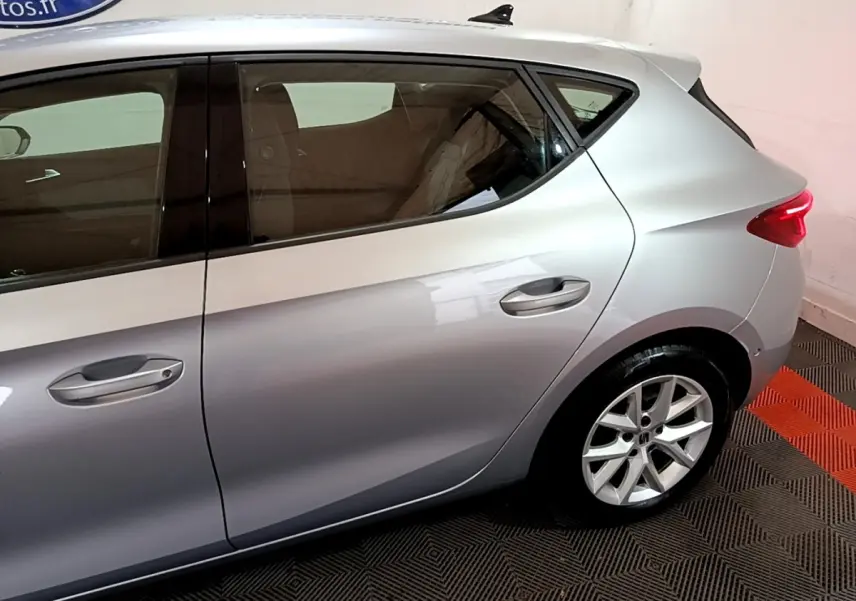 Vue latérale droite sur l'arrière d'une SEAT LEON gris foncé avec jante alliage et feux arrière allumés.