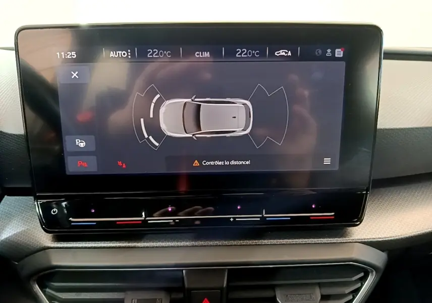 Écran tactile central du tableau de bord montrant l'aide au stationnement d'une SEAT Leon gris foncé.