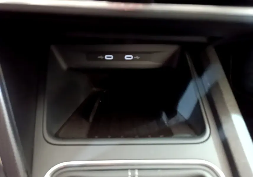 Zone de recharge par induction avec deux ports USB-C éclairés, console centrale d'une SEAT Leon gris foncé 2023.